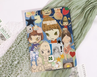 Könnte beinhalten: Ein farbenfrohes Notizbuch mit Cartoon-Illustrationen von Figuren mit großen Augen, Gitarren und Sternen. Das Cover enthält den Text "maybe not today, but someday" und "get better". Der Hintergrund ist eine Mischung aus Blau und Weiß.