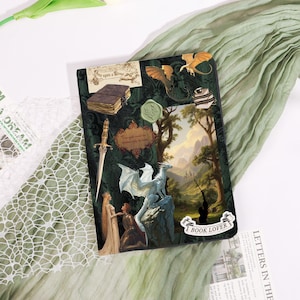 May include: A dark green book cover with fantasy-themed illustrations. The cover features a dragon, a sword, and a landscape scene. Text includes "Once upon a time" and "Book Lover". The cover has a vintage aesthetic.