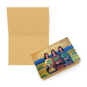 May include: Greeting card with an illustration of three women holding potted plants. The card has a tan envelope and the illustration features a landscape with blue, green, and yellow hues. Text is visible on the card.