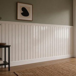 Può includere: Rivestimento a perline bianco con pannelli verticali installato su una parete con una modanatura orizzontale. La parete superiore è dipinta in un verde oliva tenue. Una stampa d'arte astratta incorniciata con una forma nera.