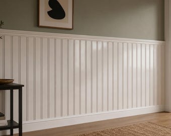 Op de afbeelding: Witte verticale kraalschroot lambrisering geïnstalleerd op een muur met een horizontale stoellijst. De muur erboven is geschilderd in een gedempt olijfgroen. Een ingelijste abstracte kunstprint met een zwarte vorm hangt aan de bovenmuur.