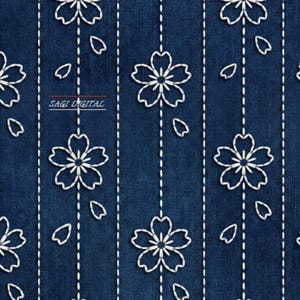 Op de afbeelding: Een naadloos patroon met witte geborduurde kersenbloesems en vallende bloemblaadjes op een donkerblauwe denim achtergrond. Verticale witte stippellijnen lopen tussen de bloemmotieven. De tekst "SAGI DIGITAL" is zichtbaar.