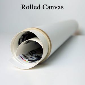 May include: A rolled canvas print, tightly rolled and secured with a cardboard core. The white canvas is visible, with the words "Rolled Canvas" printed at the top. The canvas is ready for framing or display.