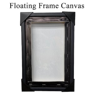 May include: A black floating frame canvas with the text "Floating Frame Canvas" at the top. The canvas is stretched over a wooden frame and secured with staples. The corners are protected with black corner protectors.