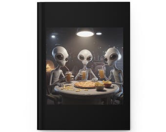 May include: Black journal featuring an illustration of three gray aliens at a table. They are drinking from glasses with straws, and there is a pizza and snacks on the table. The aliens are in a dimly lit room.