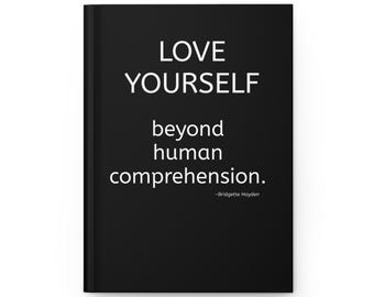 May include: A black hardcover journal featuring white text that reads LOVE YOURSELF beyond human comprehension. -Bridgette Hayden. The front cover has a clean, solid black background with the quote centered in a simple, sans-serif white font.