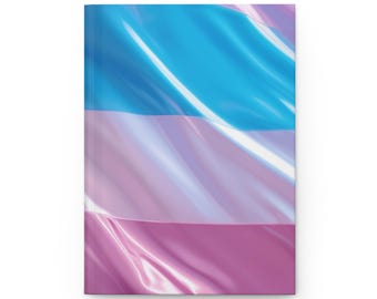 May include: A hardcover notebook with a design resembling a flowing flag. The flag features horizontal stripes in light blue, pale pink, and a darker pink. The cover has a glossy finish.