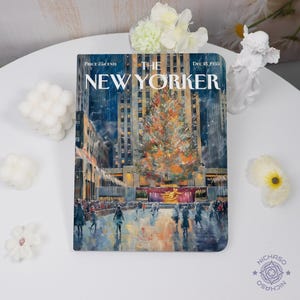 May include: A notebook featuring a vintage cover of The New Yorker magazine from December 18, 1953. The cover art depicts a Christmas tree in front of a city building. The notebook has a white background and is surrounded by decorative flowers.