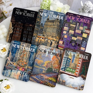 May include: Six rectangular magnets featuring various The New Yorker magazine covers. The designs include a dark city scene, a lit building, a purple building with numbered windows, a Christmas tree, an autumn park, and a window view with a cat.