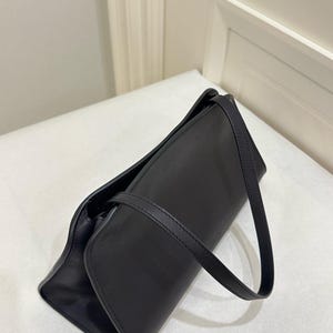 minimalist black leather bag
small luxury shoulder bag
premium black clutch purse
structured evening handbag
sleek leather top handle bag
compact designer style purse
modern black shoulder purse
elegant leather underarm bag
high end minimalist handbag
refined black leather purse
luxury small handbag women
minimal everyday leather bag
stylish black evening purse
designer look leather bag
fashion forward shoulder bag