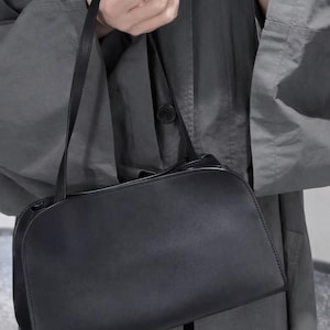 quiet luxury handbag
old money style bag
clean girl aesthetic purse
capsule wardrobe bag
timeless black handbag
contemporary leather purse
minimalist fashion accessory
elegant evening clutch
modern classic handbag
understated luxury bag
Scandinavian style bag
Parisian minimalist purse
The Row inspired bag
90s minimalist handbag
luxury basics accessory