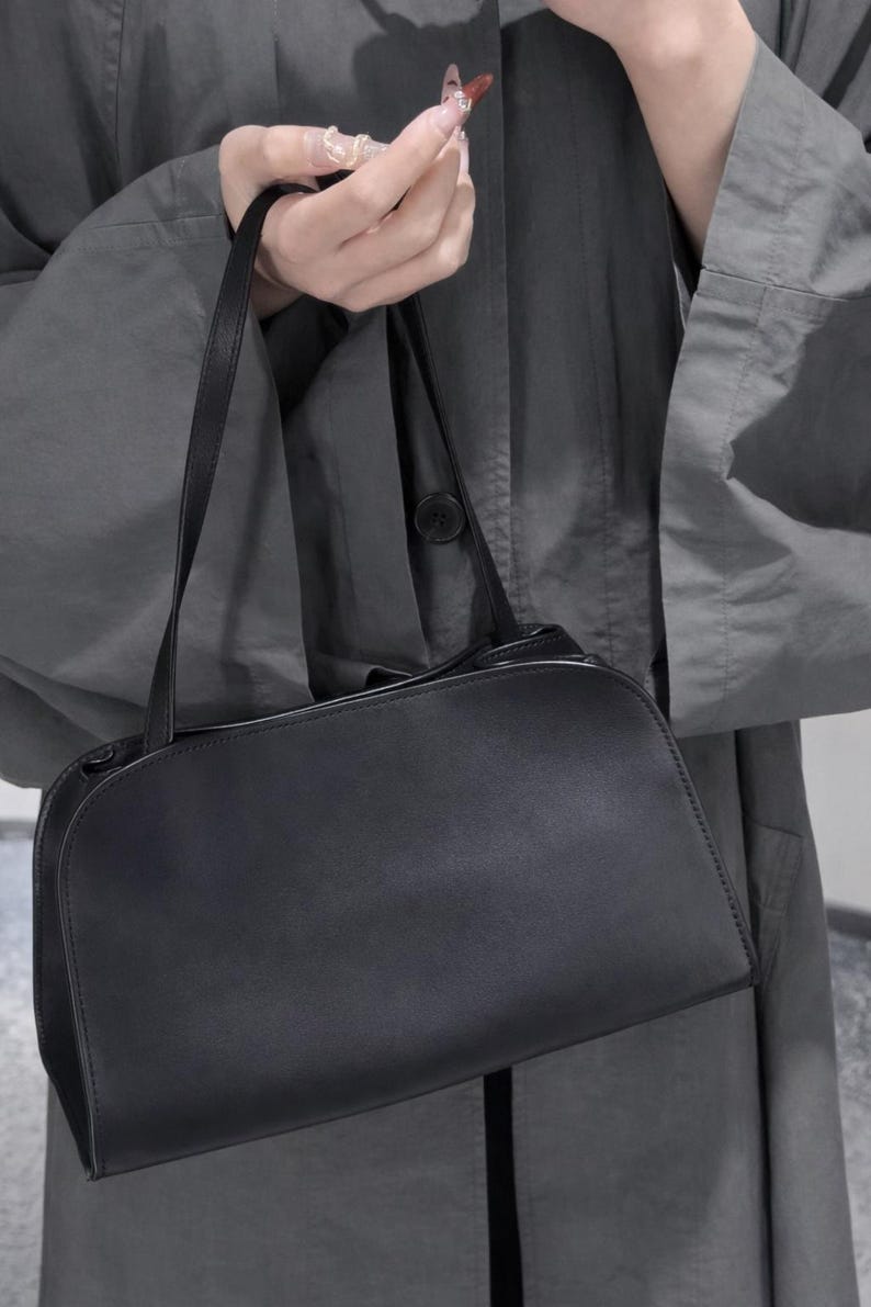 quiet luxury handbag
old money style bag
clean girl aesthetic purse
capsule wardrobe bag
timeless black handbag
contemporary leather purse
minimalist fashion accessory
elegant evening clutch
modern classic handbag
understated luxury bag
Scandinavian style bag
Parisian minimalist purse
The Row inspired bag
90s minimalist handbag
luxury basics accessory