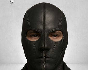May include: Black leather balaclava with a full face design, featuring eye openings and a vertical zip closure. The mask is stitched and covers the entire head and neck. A bull skull logo is in the upper left corner.