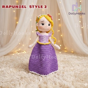 May include: A handmade crochet doll in the style of Rapunzel, featuring a purple dress, yellow hair, and a floral crown. The doll has a white face and arms, with the text "RAPUNZEL STYLE 2" in the top left corner.