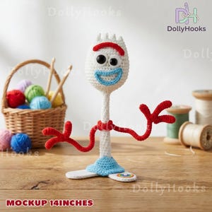 May include: A crocheted character figure with a white oval head, mismatched black eyes, a red eyebrow, and a light blue mouth. It has thin red arms, a white body, and a light blue base with a small rainbow patch. The figure is 14 inches tall.