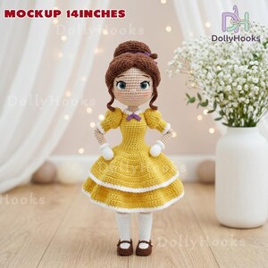 May include: A handmade crochet doll, approximately 14 inches tall, wearing a yellow dress with white accents. The doll has brown hair styled in a bun, blue eyes, and is wearing white gloves and socks. The doll is standing in front of a white background.