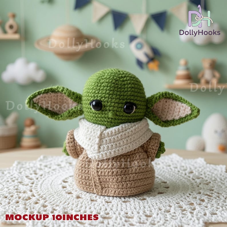 May include: A green crochet doll with large black eyes, oversized pointed ears, and a white collar, wearing a tan robe. The doll is 10 inches tall. It features a round head, a small body, and textured yarn stitches throughout the entire figure.