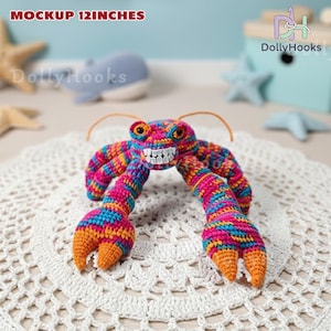 K&ouml;nnte beinhalten: Ein farbenfrohes geh&auml;keltes Hummer-Spielzeug, ca. 30 cm lang, mit einem l&auml;chelnden Gesicht und orangefarbenen Scheren. Der Hummer ist aus rosa, blauem, orangefarbenem und gelbem Garn gefertigt. Der Text "MOCKUP 12INCHES" ist sichtbar.