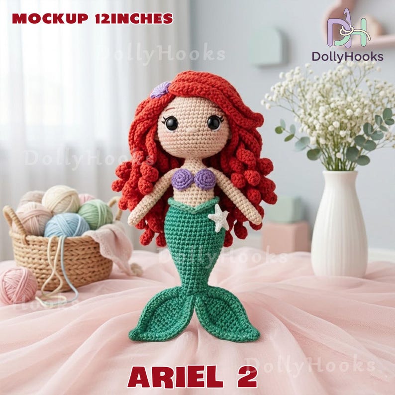 Puede incluir: Una mu&ntilde;eca de sirena de ganchillo, de aproximadamente 30 cm de altura, con cabello rojo, un top de concha p&uacute;rpura y una cola verde. La mu&ntilde;eca tiene una estrella de mar blanca y el texto "ARIEL 2". La mu&ntilde;eca se exhibe sobre una superficie rosa.