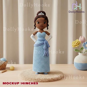 Op de afbeelding: Een handgemaakte gehaakte pop van een prinses in een lichtblauwe jurk, met een bijpassende sjaal en schoenen. De pop heeft donkerbruin haar en een tiara. De pop is ongeveer 35,5 cm hoog.