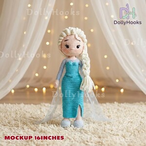 Op de afbeelding: Een handgemaakte gehaakte pop, ongeveer 40,6 cm hoog, die lijkt op een personage met blond haar in een lange vlecht. De pop draagt een turquoise jurk met een split en een doorschijnende cape. Het gezicht van de pop heeft geborduurde kenmerken.