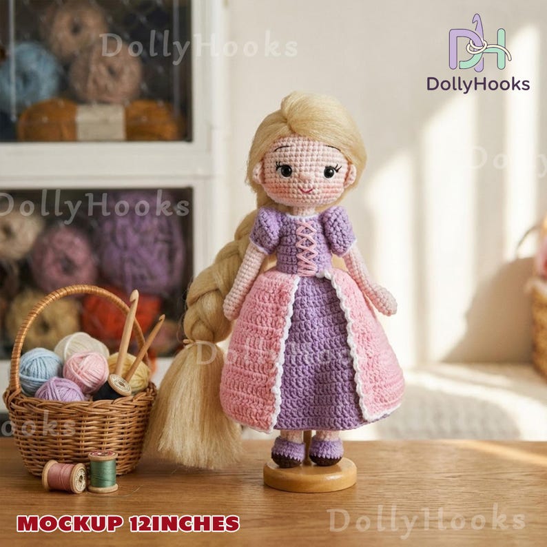 Op de afbeelding: Een handgemaakte gehaakte pop, ongeveer 30 cm hoog, met een lange blonde vlecht en een roze en paarse jurk. De pop staat op een houten standaard. De afbeelding bevat ook een mand met garen en de tekst "MOCKUP 12 INCHES".