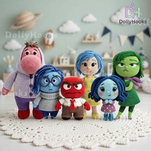 May include: A collection of six crocheted dolls featuring various characters with distinct colors and expressions, including a purple hooded figure, a blue character with glasses, a red figure with a tie, a blue-haired doll, a small blue doll, and a green doll.