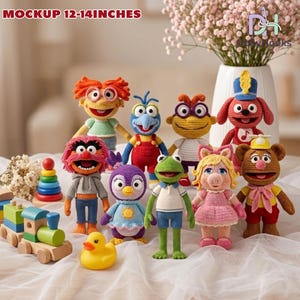 May include: A collection of handmade crochet Muppet character dolls, each approximately 12-14 inches tall. The dolls feature vibrant colors and detailed designs, including Kermit the Frog, Miss Piggy, and Fozzie Bear. A wooden train and a yellow rubber duck are also present.