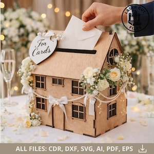 Può includere: Una scatola per biglietti in legno a forma di casa, decorata con fiori bianchi, perle e nastri. La scatola ha una fessura per le carte e un'etichetta a forma di cuore con la scritta "For Cards". Una mano sta inserendo una carta nella fessura. L'immagine include anche il testo "ALL FILES: CDR, DXF, SVG, AI, PDF, EPS".