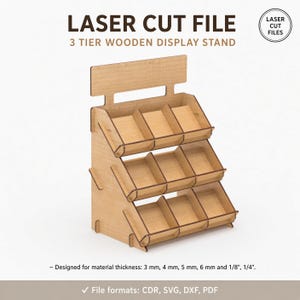 Peut inclure: Un fichier de découpe laser pour présentoir en bois à 3 niveaux. Le texte indique : LASER CUT FILE, 3 TIER WOODEN DISPLAY STAND, LASER CUT FILES, et Designed for material thickness: 3 mm, 4 mm, 5 mm, 6 mm et 1/8", 1/4". Formats : CDR, SVG, DXF, PDF.