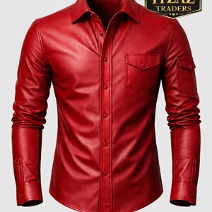 Op de afbeelding: Een felrood leren shirt met lange mouwen, een knoopsluiting en twee borstzakken. Het shirt heeft een klassieke kraag en manchetten met knopen. De afbeelding bevat een logo met de tekst "REAL LEATHER ITZAZ TRADERS."