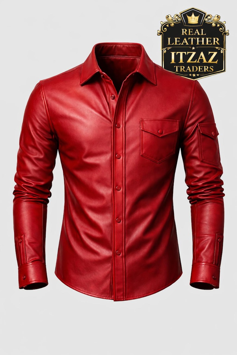 Op de afbeelding: Een felrood leren shirt met lange mouwen, een knoopsluiting en twee borstzakken. Het shirt heeft een klassieke kraag en manchetten met knopen. De afbeelding bevat een logo met de tekst "REAL LEATHER ITZAZ TRADERS."