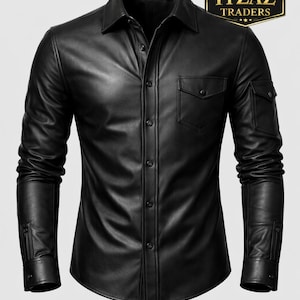 Könnte beinhalten: Schwarzes Lederhemd mit Kragen, geknöpften Manschetten und zwei Brusttaschen. Das Hemd hat auch zwei Ärmeltaschen. Das Logo "REAL LEATHER ITZAZ TRADERS" befindet sich in der oberen rechten Ecke.