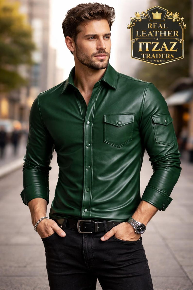 Op de afbeelding: Een donkergroen leren overhemd met twee borstzakken en knopen. Het overhemd wordt gecombineerd met een zwarte broek en een zwarte riem. De afbeelding bevat de tekst "REAL LEATHER ITZAZ TRADERS".