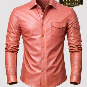 Op de afbeelding: Koraalrood leren overhemd met een knoopsluiting, een kraag en lange mouwen. Het overhemd heeft twee borstzakken en twee extra zakken op de mouwen. Het "REAL LEATHER ITZAZ TRADERS" logo staat rechtsboven.