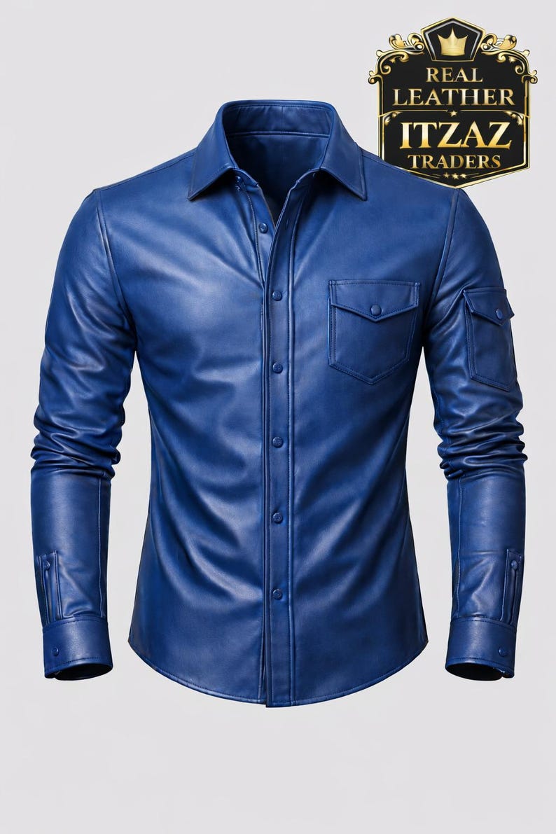 Op de afbeelding: Een blauw leren overhemd met een knoopsluiting, een borstzak en een mouwzak. Het overhemd heeft lange mouwen en een klassieke kraag. De afbeelding bevat een logo met de tekst "REAL LEATHER ITZAZ TRADERS".