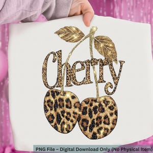 Op de afbeelding: Witte achtergrond met een glinsterend gouden en luipaardprint kersendesign. Het woord "Cherry" is geschreven in een luipaardprint lettertype. De kersen hebben een luipaardprint patroon met gouden glitter accenten. Digitale download.