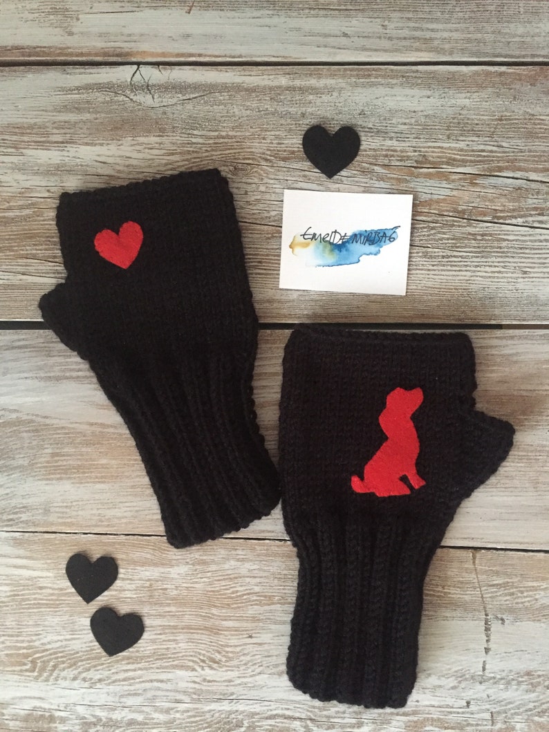 May include: A pair of black fingerless gloves with red felt accents. One glove has a heart shape and the other has a dog silhouette.