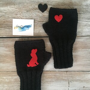 May include: A pair of black fingerless gloves with red felt appliques. One glove has a heart shape and the other has a dog silhouette.