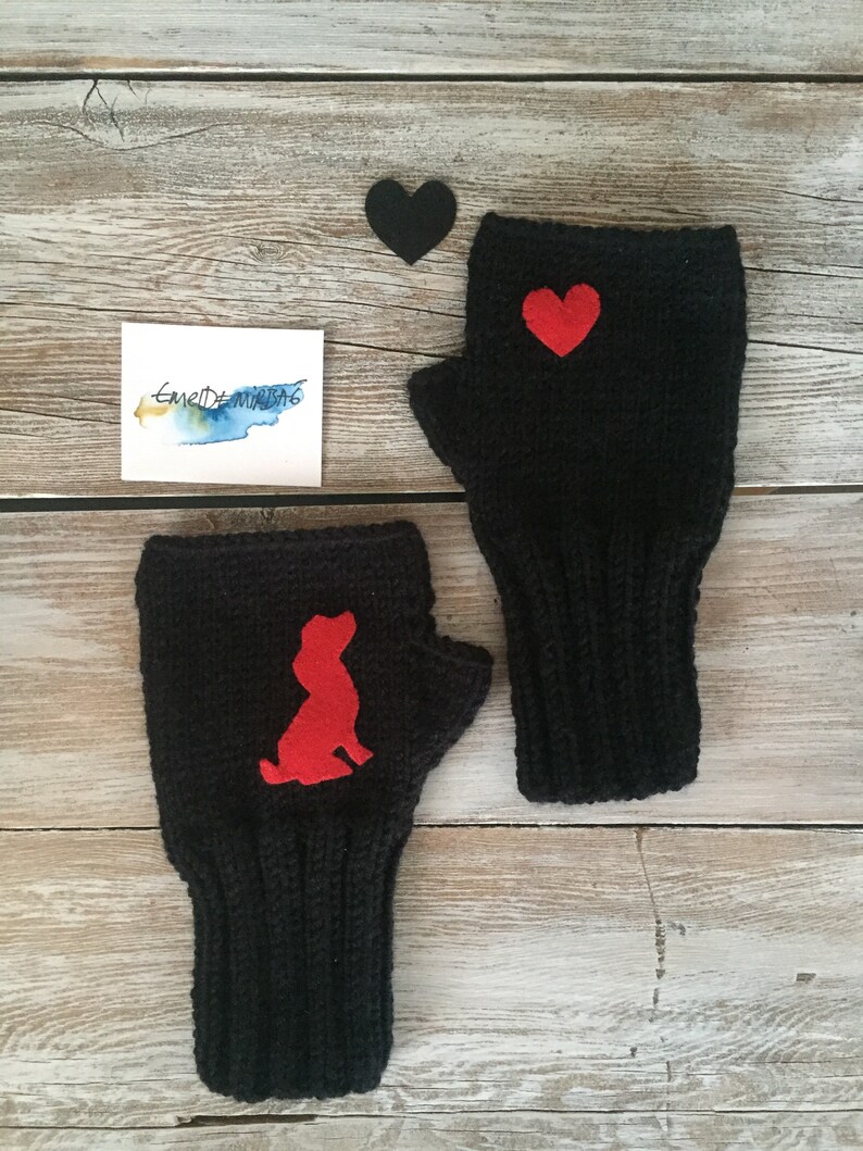 May include: A pair of black fingerless gloves with red felt appliques. One glove has a heart shape and the other has a dog silhouette.