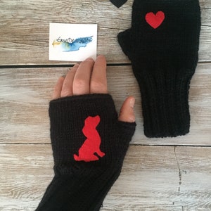 May include: A pair of black fingerless gloves with red felt appliques. One glove has a heart shape and the other has a dog silhouette.