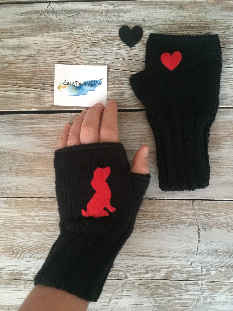 May include: A pair of black fingerless gloves with red felt appliques. One glove has a heart shape and the other has a dog silhouette.