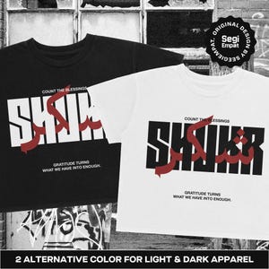 Może przedstawiać: Czarny t-shirt i biały t-shirt, oba z napisem SHUKR dużymi literami blokowymi oraz czerwoną arabską czcionką. Nad tekstem znajduje się napis COUNT THE BLESSINGS, a pod nim GRATITUDE TURNS WHAT WE HAVE INTO ENOUGH. Okrągłe logo zawiera napis ORIGINAL DESIGN BY SEGIEMPAT.