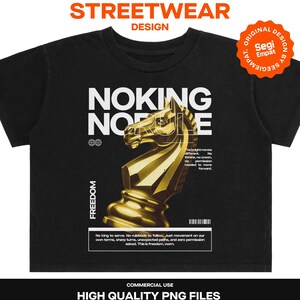 Könnte beinhalten: Ein schwarzes T-Shirt mit einer goldenen Schachspringer-Grafik und weißem Text, der NOKING NORULE, FREEDOM sowie weiteren Text über Bewegung enthält, dazu eine Strichcode-Grafik und ein kreisförmiges orangefarbenes Abzeichen mit Segi Empat.