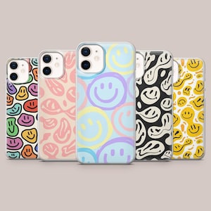 Puede incluir: Una colección de cinco fundas para teléfonos con coloridos diseños de caras sonrientes. Las fundas presentan diseños en varios colores, incluyendo rosa, azul, amarillo, negro y morado. Cada funda tiene un patrón diferente, con caras sonrientes repetidas o diseños abstractos.