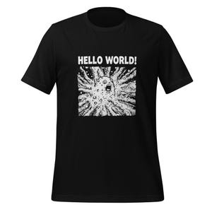 Op de afbeelding: Zwart T-shirt met een witte grafische afbeelding. De afbeelding toont een schreeuwend gezicht omringd door stralende lijnen en de woorden "HELLO WORLD!" in het wit. Het T-shirt is gemaakt van zacht materiaal.