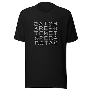 Può includere: T-shirt nera con la scritta bianca "ZATOR AREPO TENET OPERA ROTAS" disposta verticalmente. La maglietta ha maniche corte e girocollo.