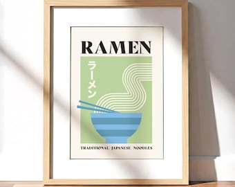Puede incluir: Una impresión artística enmarcada con un diseño minimalista de ramen. La obra de arte incluye la palabra "RAMEN" en negro, caracteres japoneses, un cuenco azul, palillos y el texto "TRADITIONAL JAPANESE NOODLES". El marco es marrón claro.