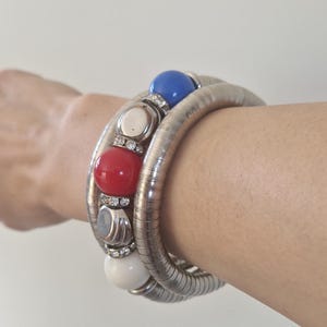 Pulsera vintage Y2K con cuentas rojas, azules y blancas en tono plateado, brazalete llamativo y robusto.