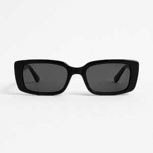 May include: Black rectangular sunglasses with dark lenses. The sunglasses feature a thick, glossy black frame and a classic, slightly oversized design. The lenses are a dark grey colour, offering a sleek and modern appearance.